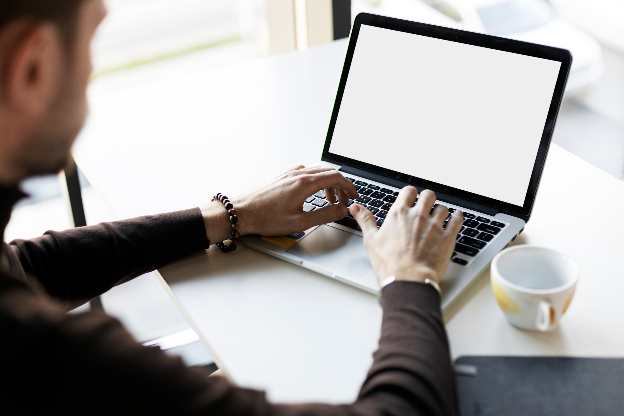 Freelancer worker using laptop, tipping, working on online project, sitting at workplace
