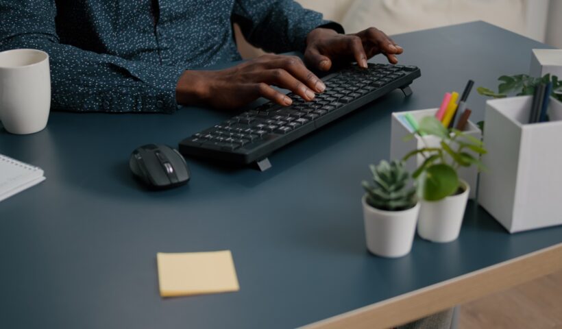 Top view of black man african american hands typing on computer keybord