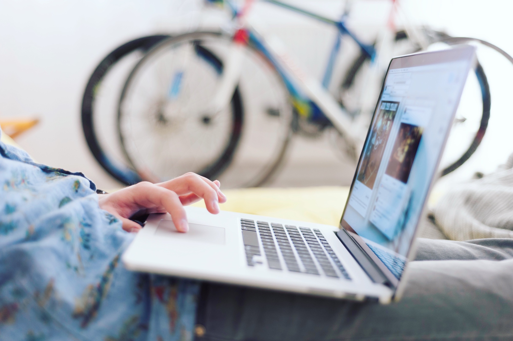 Detail of young man with laptop with bicycles in the background