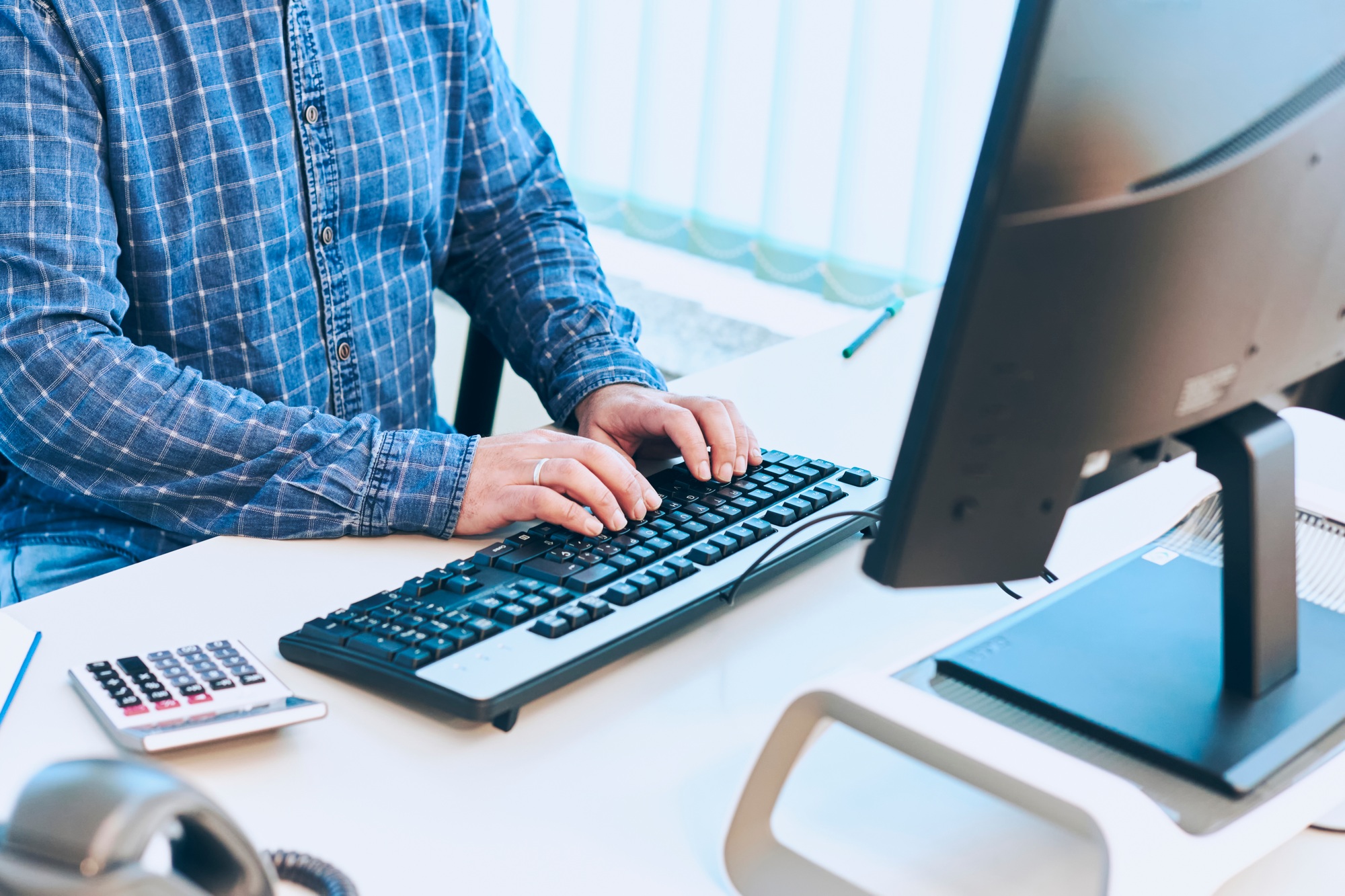 man typing pc viewed from the neck down typing on an office