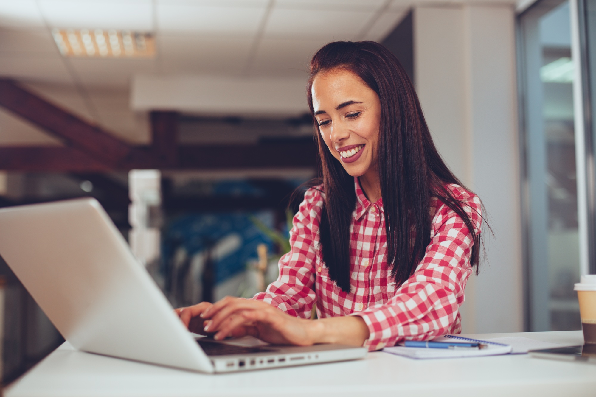 Young woman typing on laptop in the office