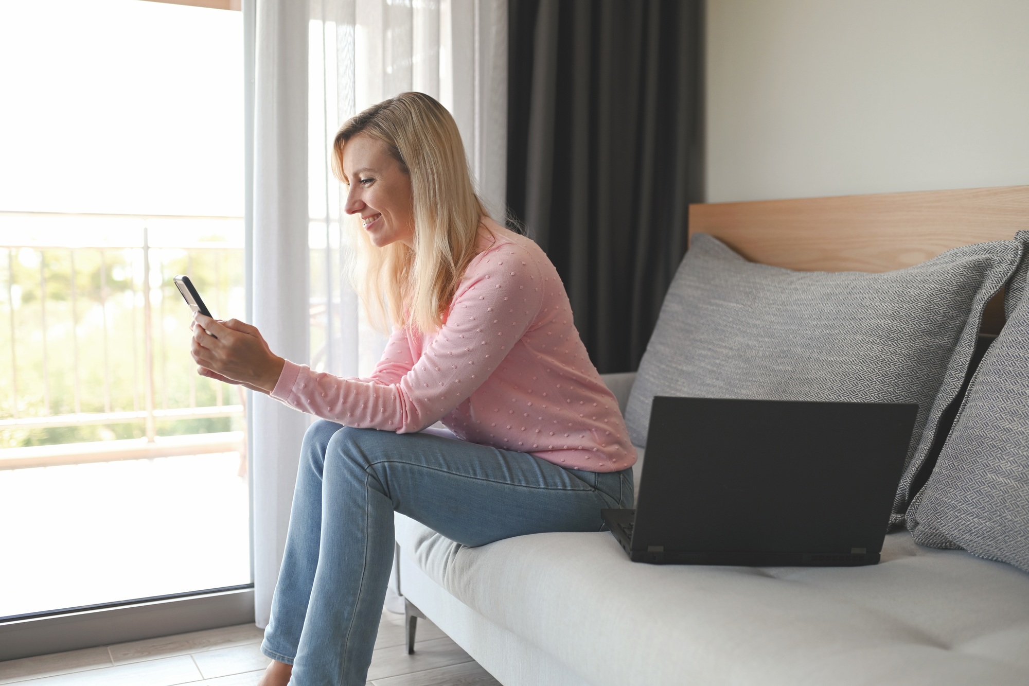 Young woman using phone and have a video chat or checking social media accounts from home