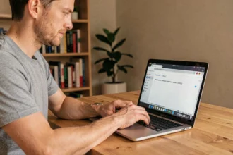 Homme accédant à l'interface admin d'un routeur via l'adresse IP 192.168.1.1 sur un ordinateur portable